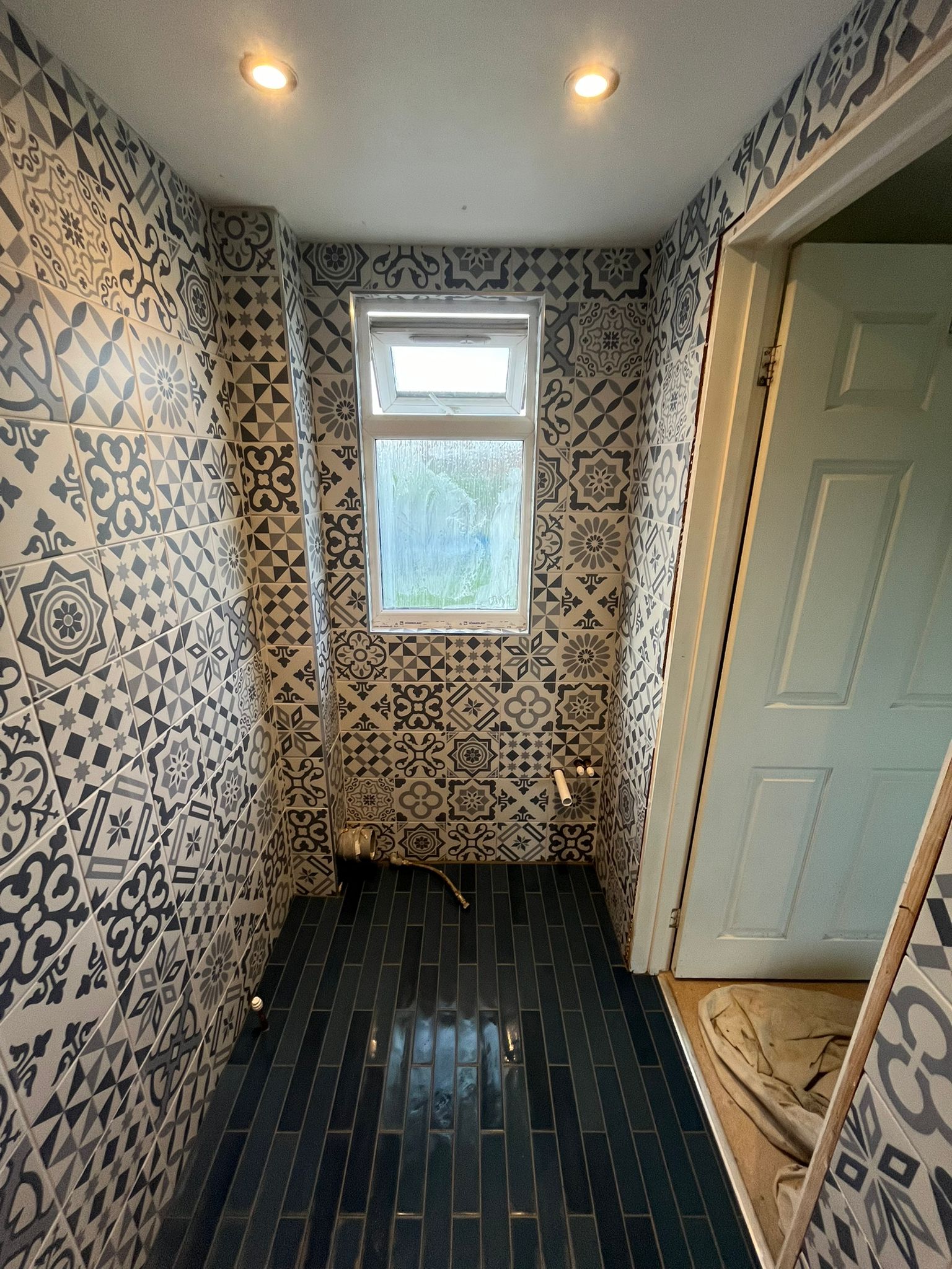 Patchwork mosaic bathroom with dark floor tiles